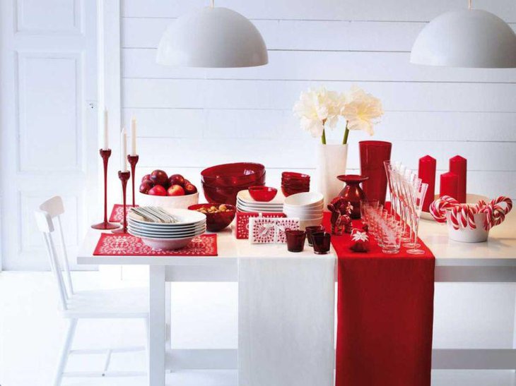 A holiday table decked up with multiple red and white accessories