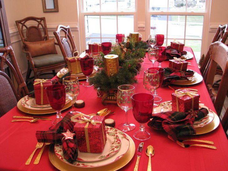 A lavish Christmas table setting with cute gift boxes set over dinner plates