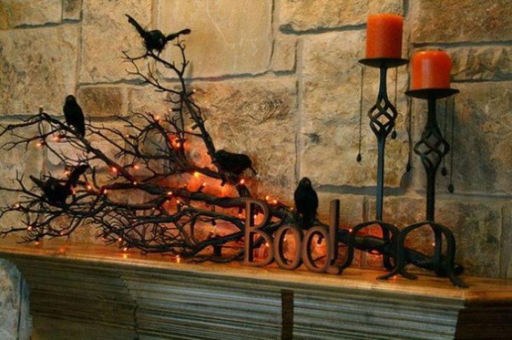 A lit up tree branch Halloween centerpiece with ravens