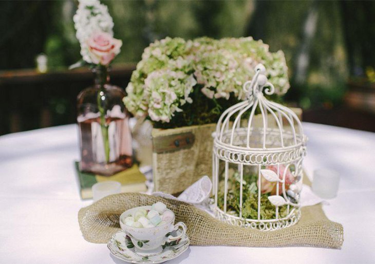 Alluring floral accented birdcage centerpiece on wedding table 1