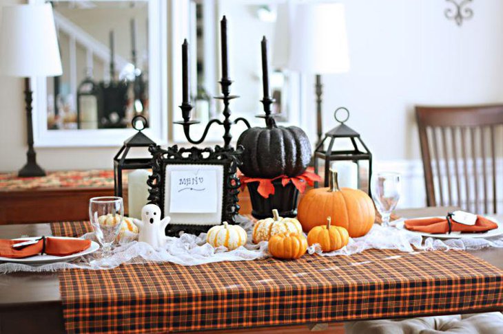 Amazing black and orange pumpkins as Halloween table decorations along with black candles