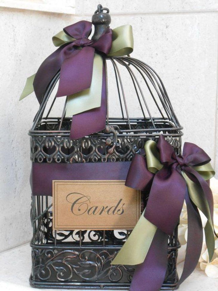 Amazing black birdcage wedding table centerpiece with purple ribbons