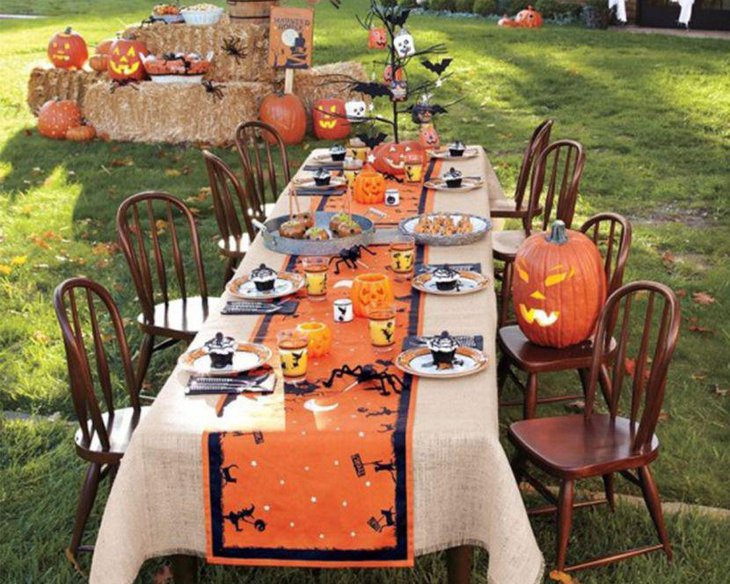 Amazing outdoor Halloween table decor with orange runner and pumpkin
