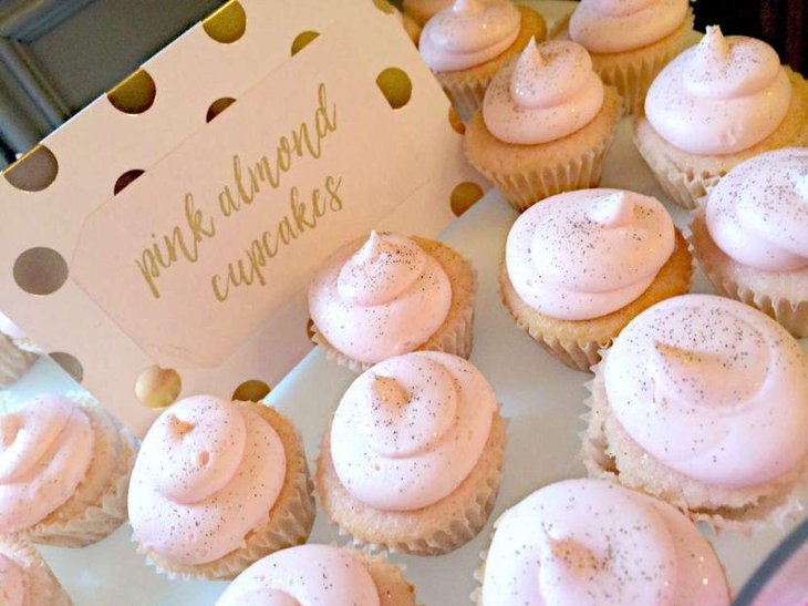 Amazing pink and golden glittery almond cupcake decor on bridal shower dessert table
