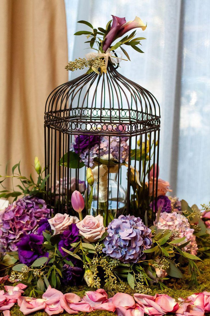 Astonishing birdcage centerpiece with purple floral accents
