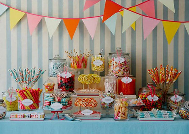 Attractive dessert table decorated with candies in glass jars