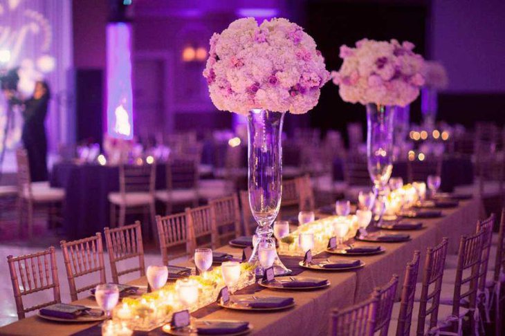 Attractive wedding table decor with tall purple floral centerpiece