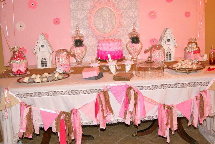 Baby shower dessert table idea with pink accents on cake bows and candies
