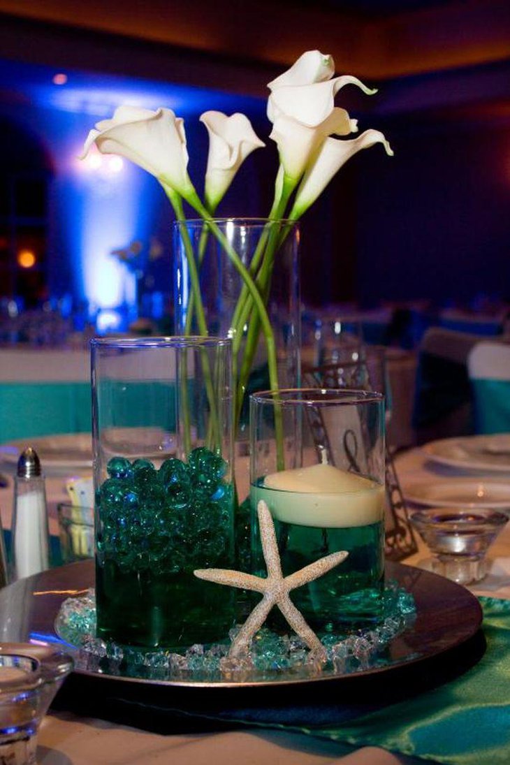 Beach themed wedding table setting with lily arrangement