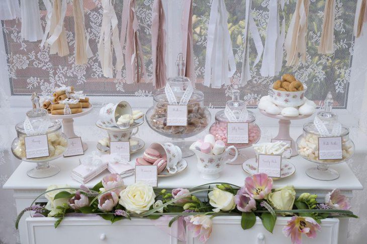 Beautiful dessert table arrangement with glass jars and ceramic cups