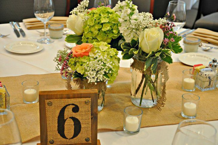 Beautiful flower arrangement in mason jars for wedding table