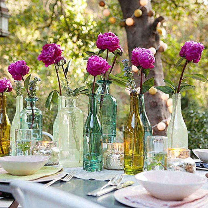 Beautiful garden party table decor with coloured bottles and pink roses