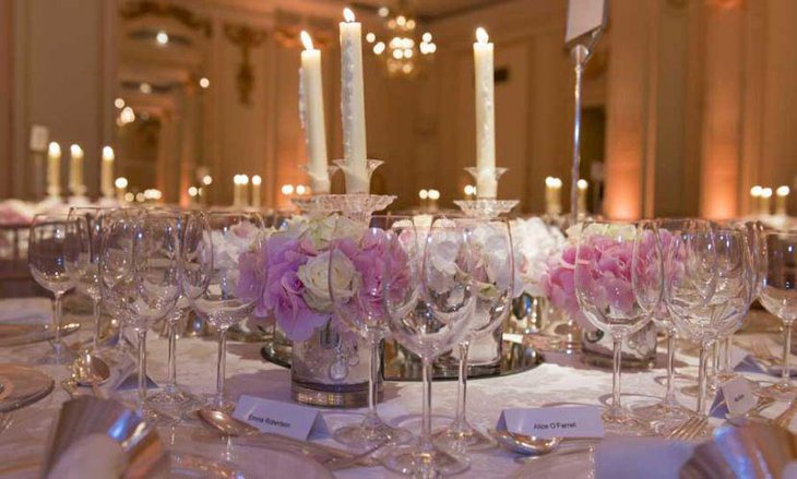 Beautiful wedding reception table decor with pink and white roses and candles
