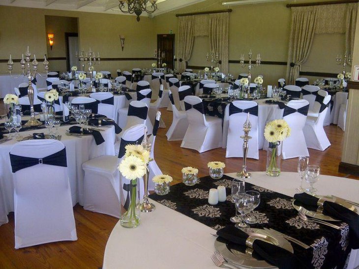 Black and white wedding decor with black embossed table runner and golden accents
