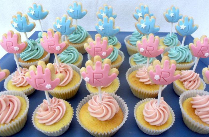 Blue and pink themed twin baby shower cupcake decor on table