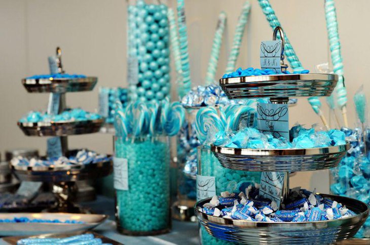 Blue inspired baby shower candy buffet table decor using decanters filled with blue candies