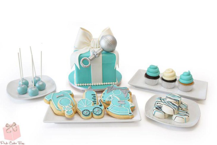 Blue themed baby shower candy table with blue cake and cookies
