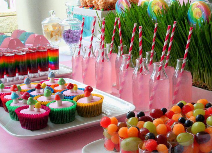 Cheerful dessert table design with pink bottled beverage and cupcakes