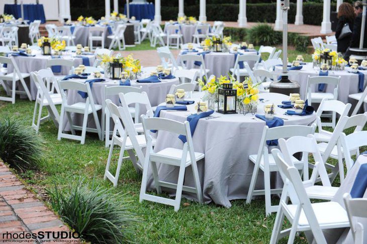 Chic garden party table decor with yellow flowers and blue napkins
