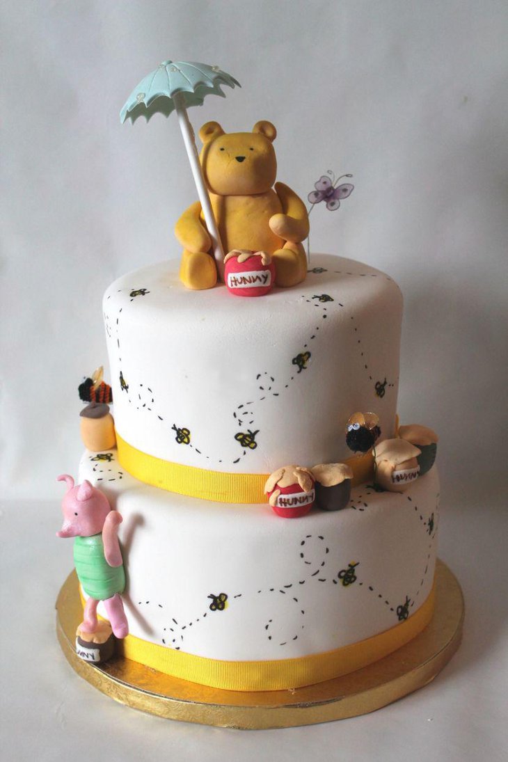 Classic Winnie The Pooh baby shower cake decor with yellow ribbons and Pooh bear