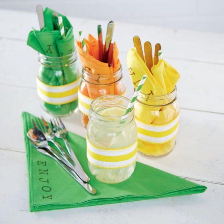 Colorful cutlery holding mason jars for wedding table