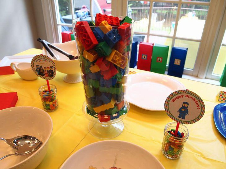 Colourful jar filled with Lego blocks as birthday table centerpiece