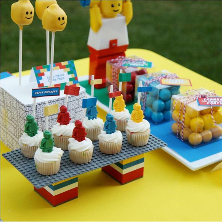 Colourful Lego party table decor idea with Lego cupcakes cake pops and gifts