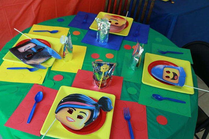 Colourful Lego party table decoration using masks square plates and Lego man printed straw covers