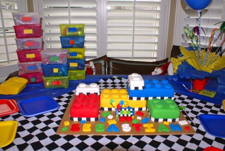 Colourful Lego themed birthday table with transparent boxes red tin pales and candy canes