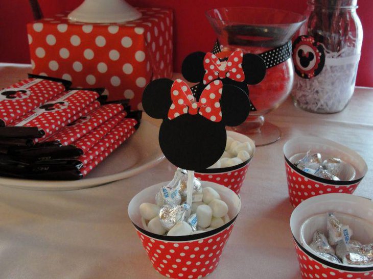Creative Minnie Mouse polka dotted bucket decorations on candy table