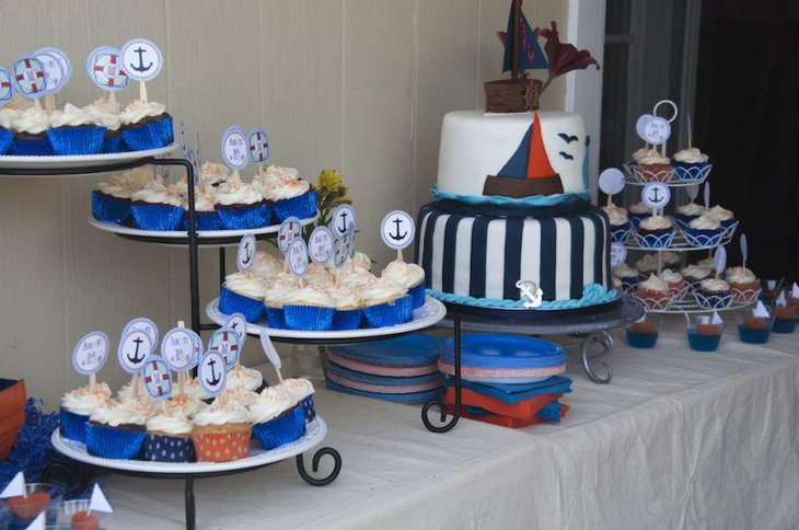 Cute boy baby shower table decoration with anchor cupcakes and boat imprinted cake