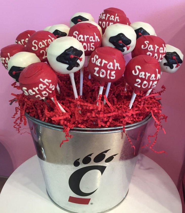 Cute graduation bucket centerpiece filled with red and white cake pops