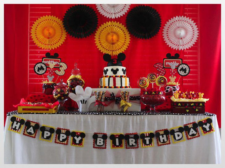 Cute Mickey Mouse table decoration with Mickey cake and buntings