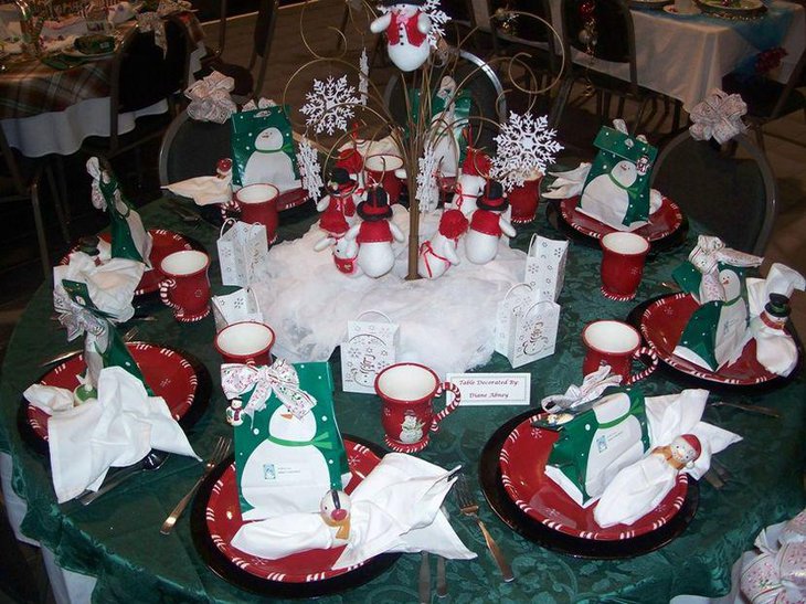 Cute snowman figurines and a tree centerpiece as Christmas party table decor