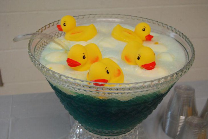 Cute yellow floating rubber duckies as table centerpieces for baby shower
