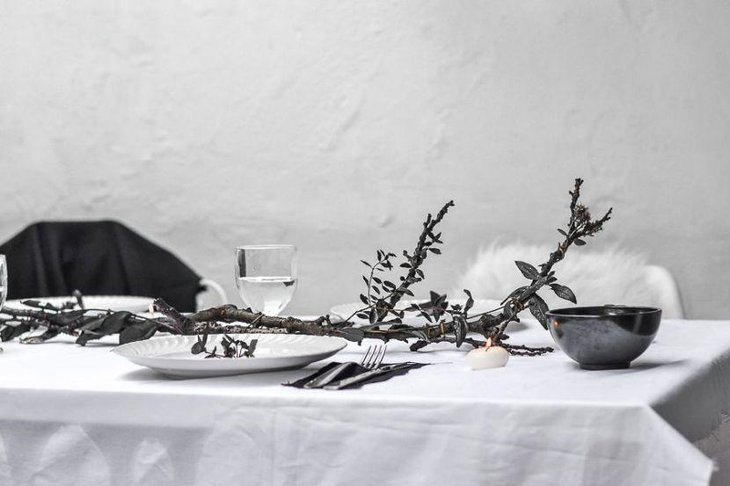Elegant DIY Halloween table decor with a black tree branch as centerpiece