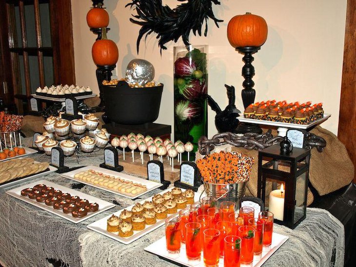 Fantastic Halloween table decor with silver skull black couldron and pumpkins on black holders