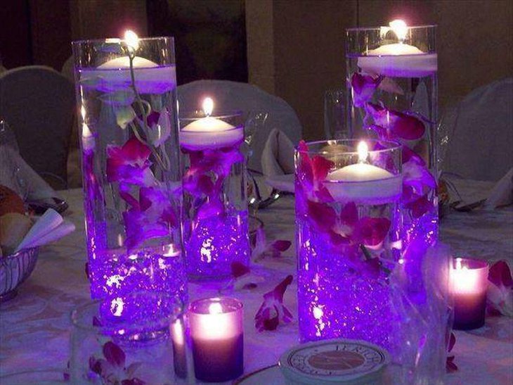 Floating candle wedding table centerpiece with purple tones