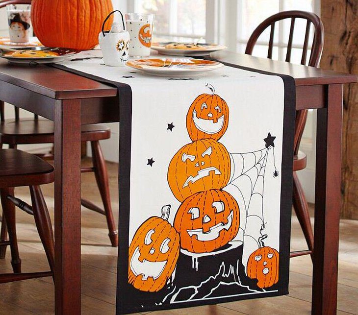 Fun kids Halloween table decor with pumpkin and white and black table runner