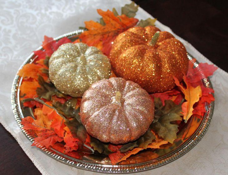 Glittery pumpkins on tray as Halloween centerpieces