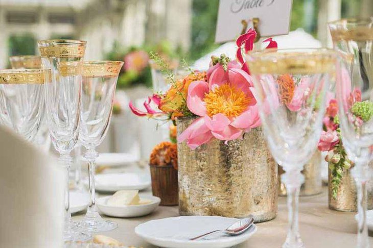 Golden themed floral vase decoration on wedding table
