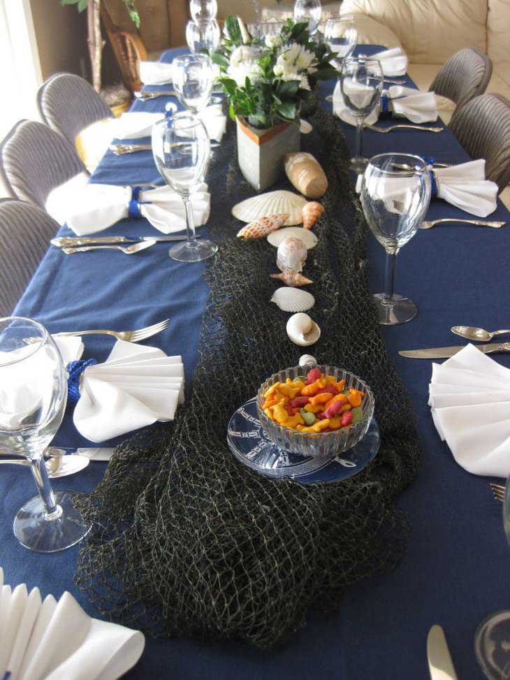 Gorgeous nautical baby shower table decor with sea shells and floral boat centerpiece