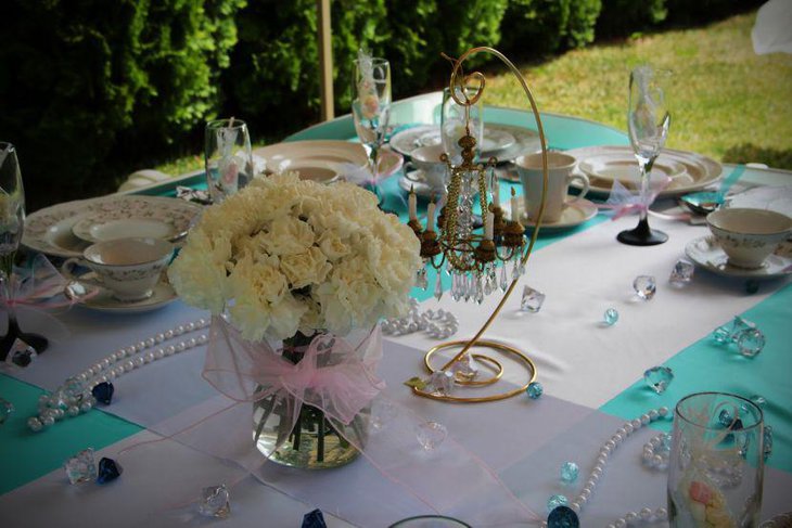 Gorgeous wedding breakfast table decor with flowers and ornamental candle holder