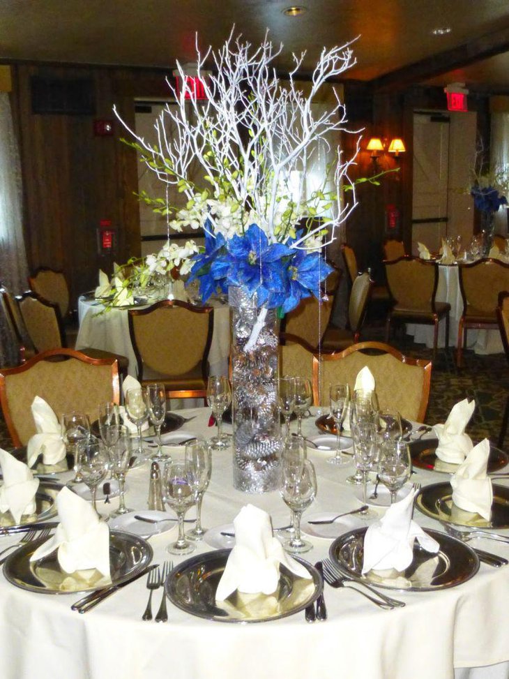 Gorgeous winter table decor with glass cylindrical vase with blue flowers