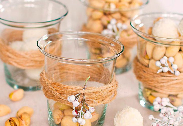 Innovative winter table decor with votives tied with twine and sprig of berries