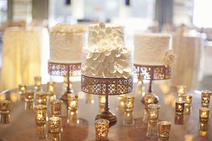 Innovative Winter wedding table setting with rich golden cakestands and mini lanterns