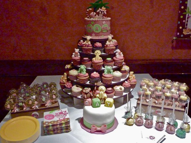 Jungle themed dessert table decorated with adorable cupcakes and candies with animal designs