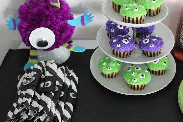 Kids Halloween party table decor with monster cupcakes and monster toy
