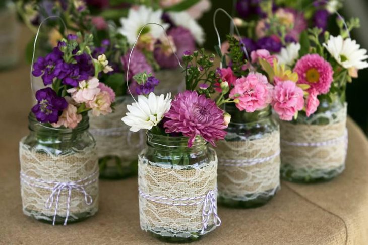 Mason Jar Containing Flowers Decorated with Burlap Lace
