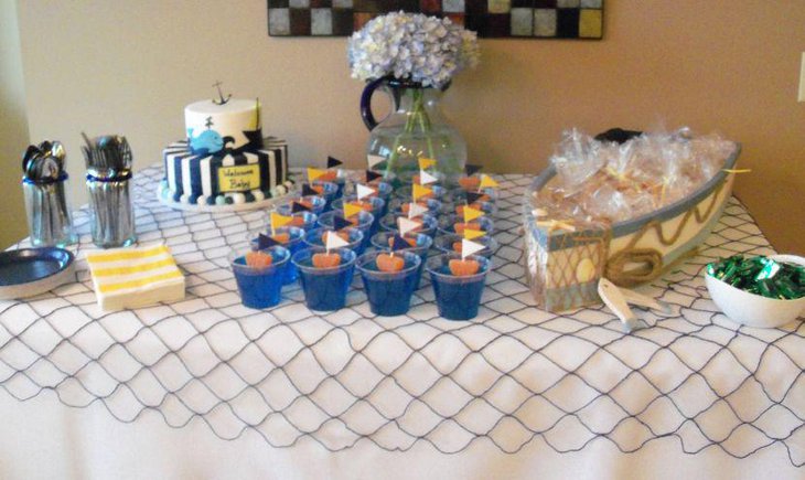 Nautical baby cake table decor with sail boat and floral jar